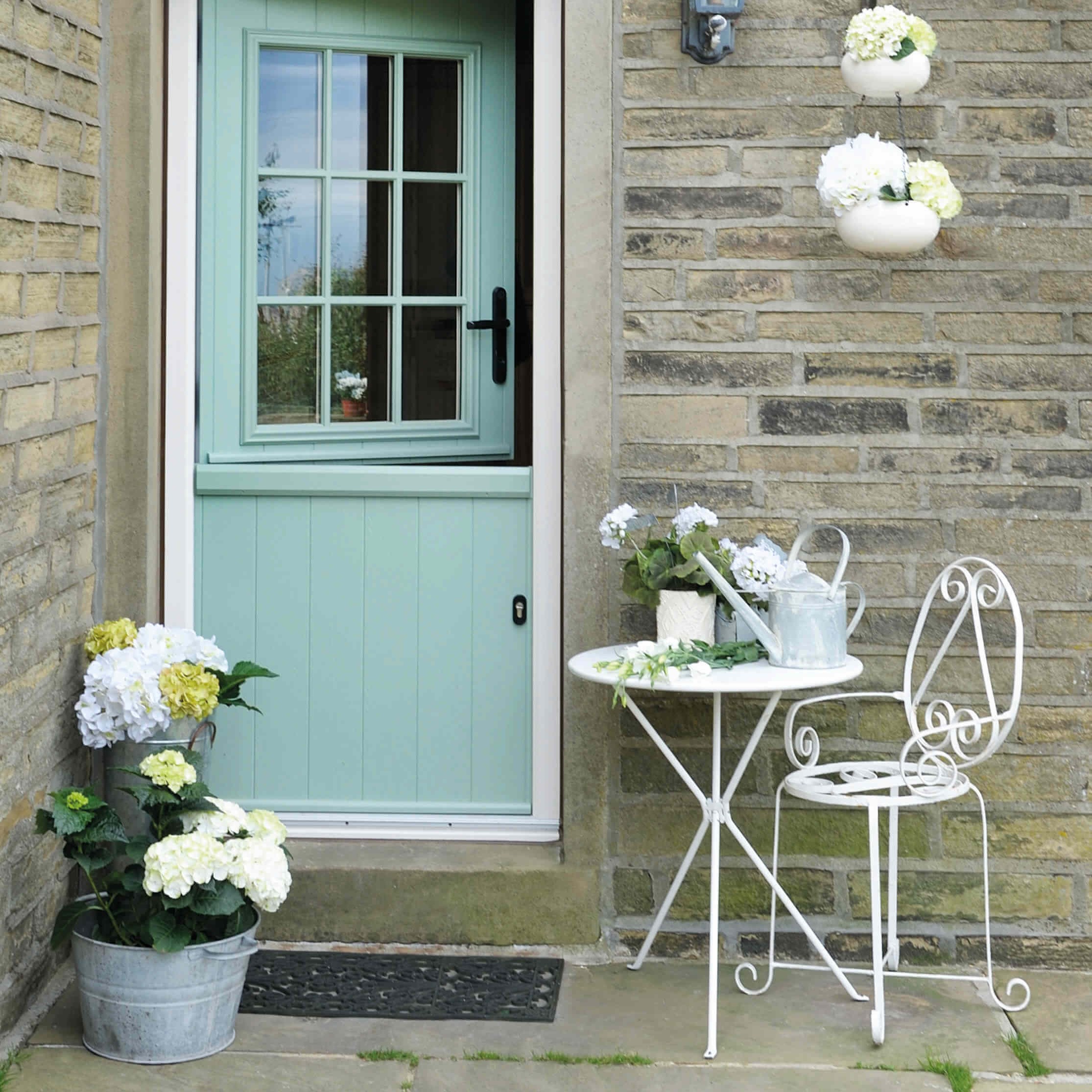 Green half open stanle door with outdoor table and chairs
