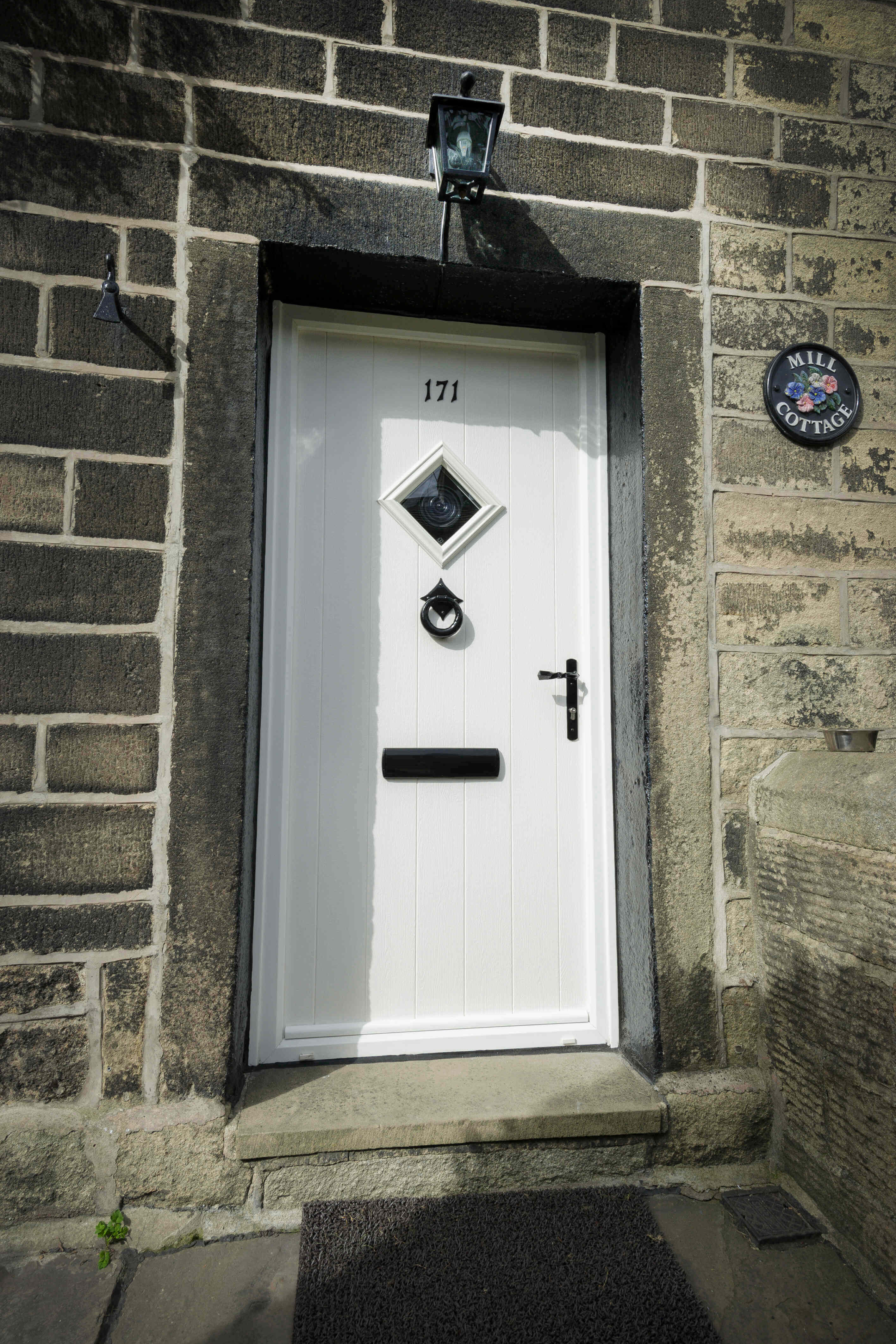 White front door of stone cottage