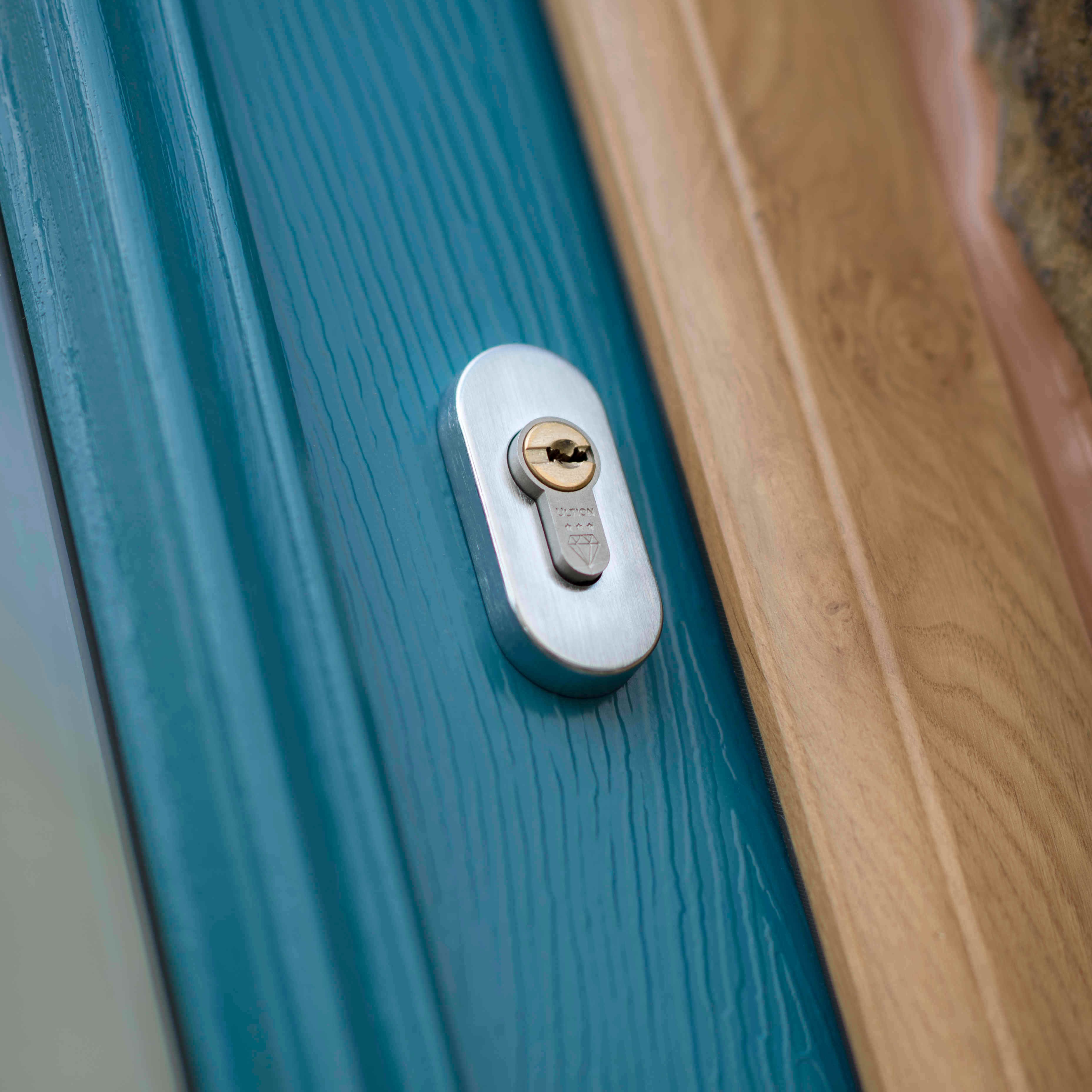 Blue door with wooden frame focused on silver ultion key lock