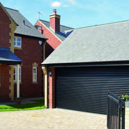 Black garage door with house on the left