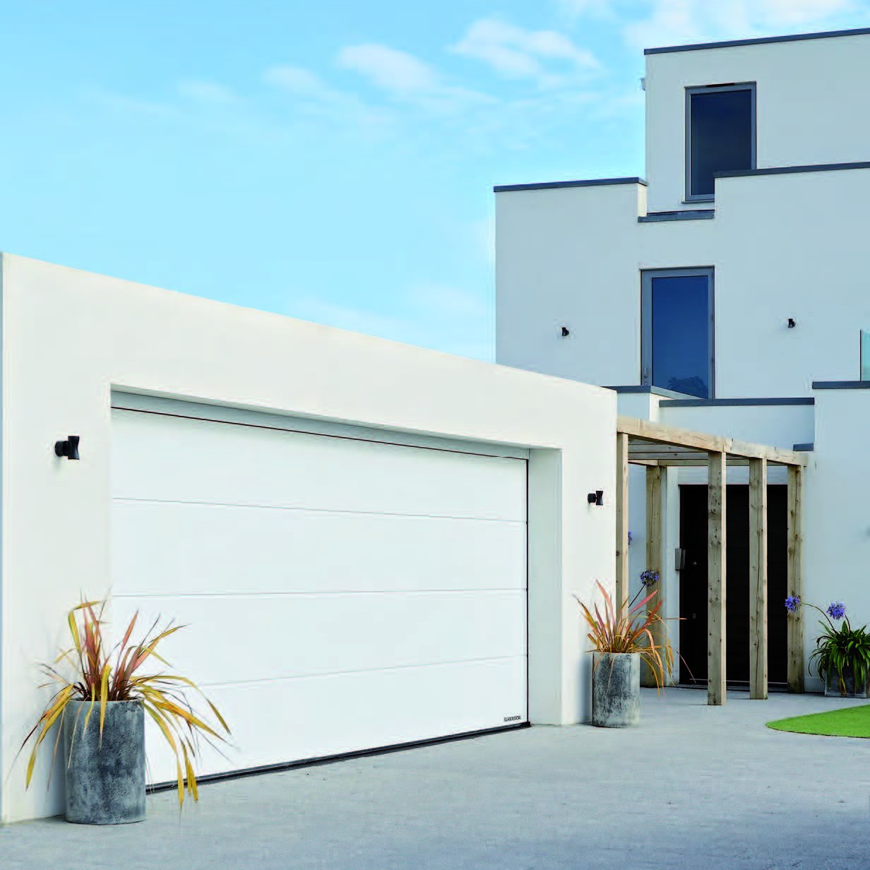 White garage door with blue sky and house in background
